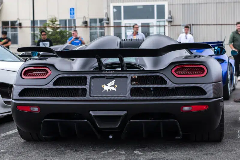 Rear view of a matte black Koenigsegg Agera RS, highlighting its distinctive aerodynamic wing, exhaust, and aggressive design elements.