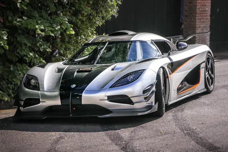 Silver Koenigsegg One:1 hypercar parked outdoors, displaying aggressive styling, carbon fiber details, and striking aerodynamic design.