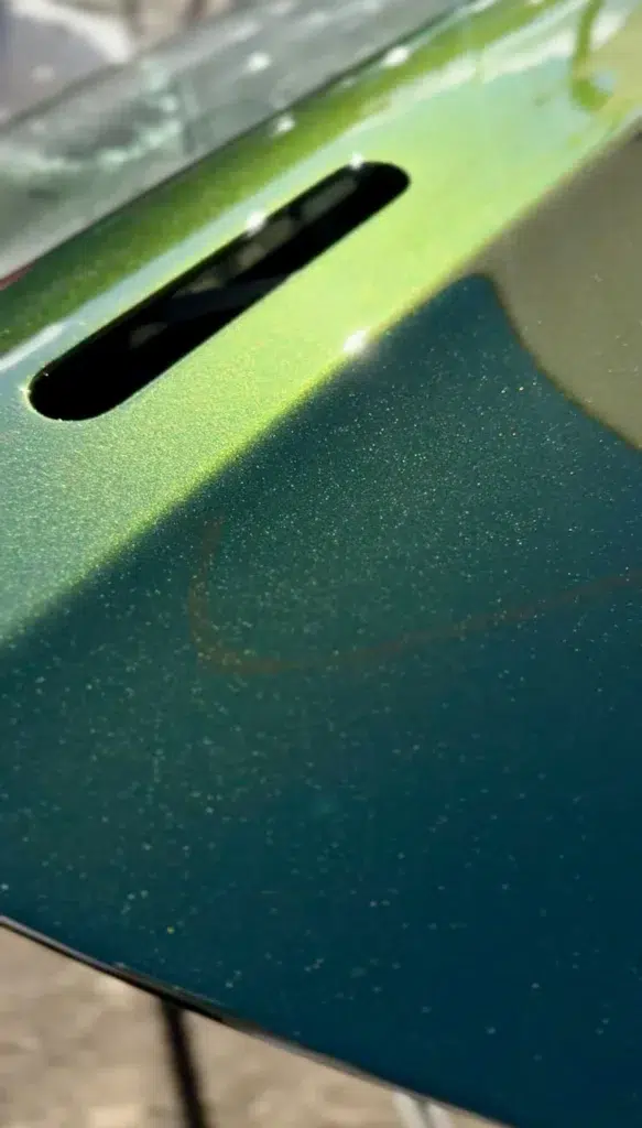 Macro view of a high-gloss metallic car paint surface showing flawless finish and sparkle