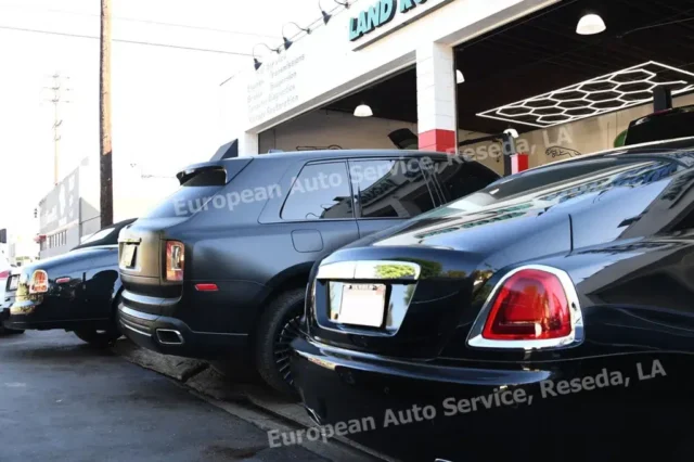 Multiple Rolls-Royce vehicles, including a Cullinan and a Ghost, parked outside European Auto Service in Los Angeles