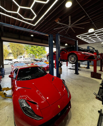 Ferrari 488 GTB inside European Auto Service repair bay with multiple lifts and professional LED lighting in Los Angeles