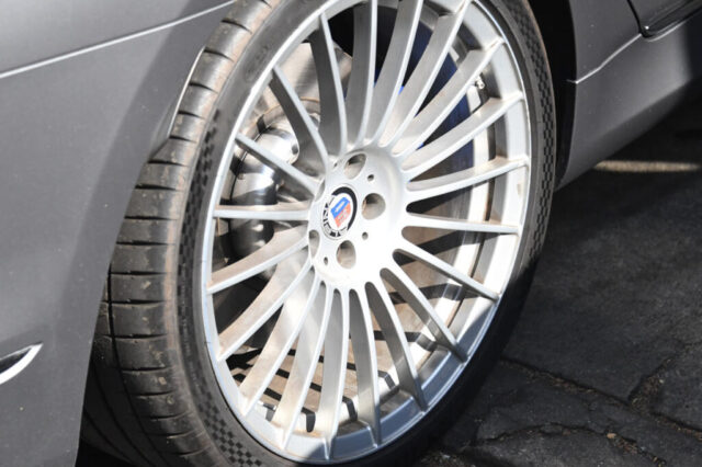 Close-up of Alpina B7 performance wheel during service Detailed view of Alpina B7 front wheel and tire at European Auto Service