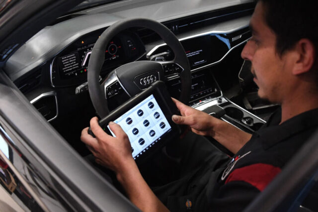 Technician Running Diagnostics on Audi RS6 at European Auto Service Reseda Interior of Audi RS6 with technician using diagnostic tablet at auto shop in Reseda
