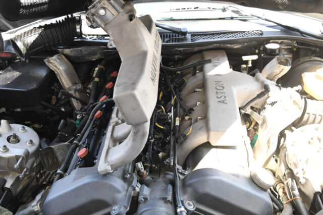 aston-martin-v12-engine-bay-intake-manifold-diagnostic-inspection Aston Martin V12 engine bay with branded intake manifold and ignition coil wiring during diagnostic inspection at European Auto Service