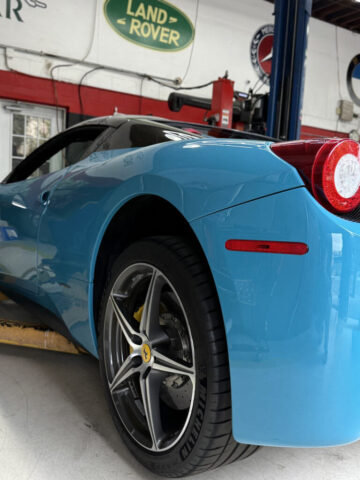 Blue Ferrari 458 Italia with yellow brake calipers at European Auto Service specialized repair shop in Reseda