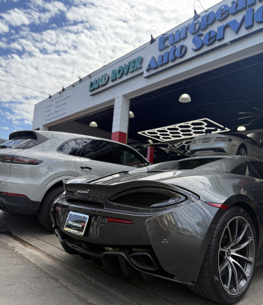 Gray McLaren 570S parked at European Auto Service storefront in Reseda with Land Rover signage visible
