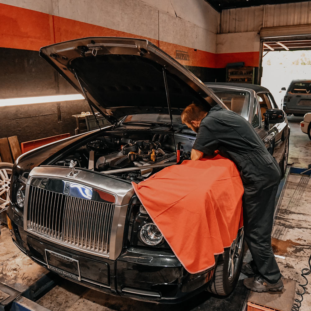 Technician performing Rolls-Royce engine repair at European luxury auto service in Los Angeles