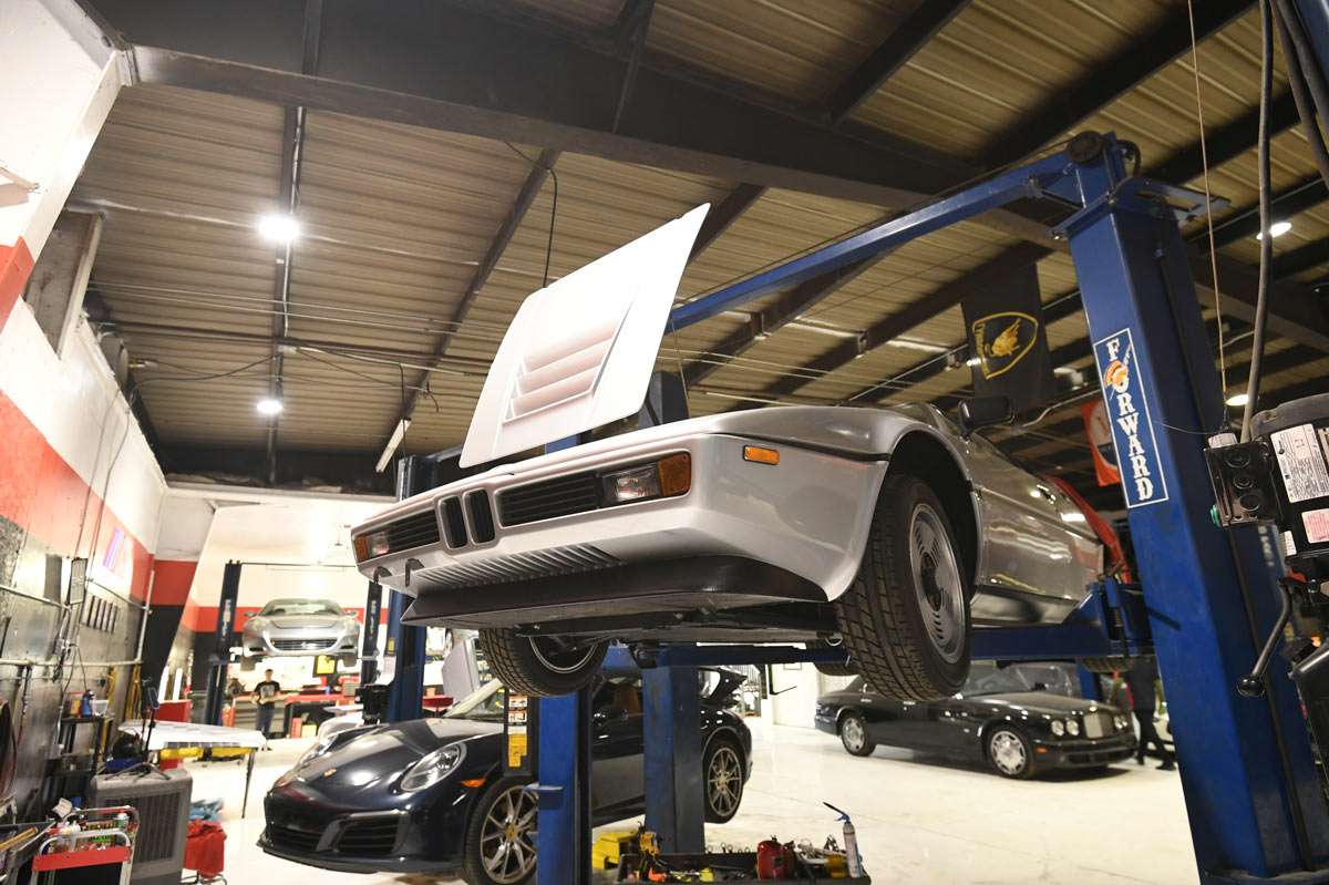 BMW M1 with front clamshell raised on the lift during cooling system and engine service