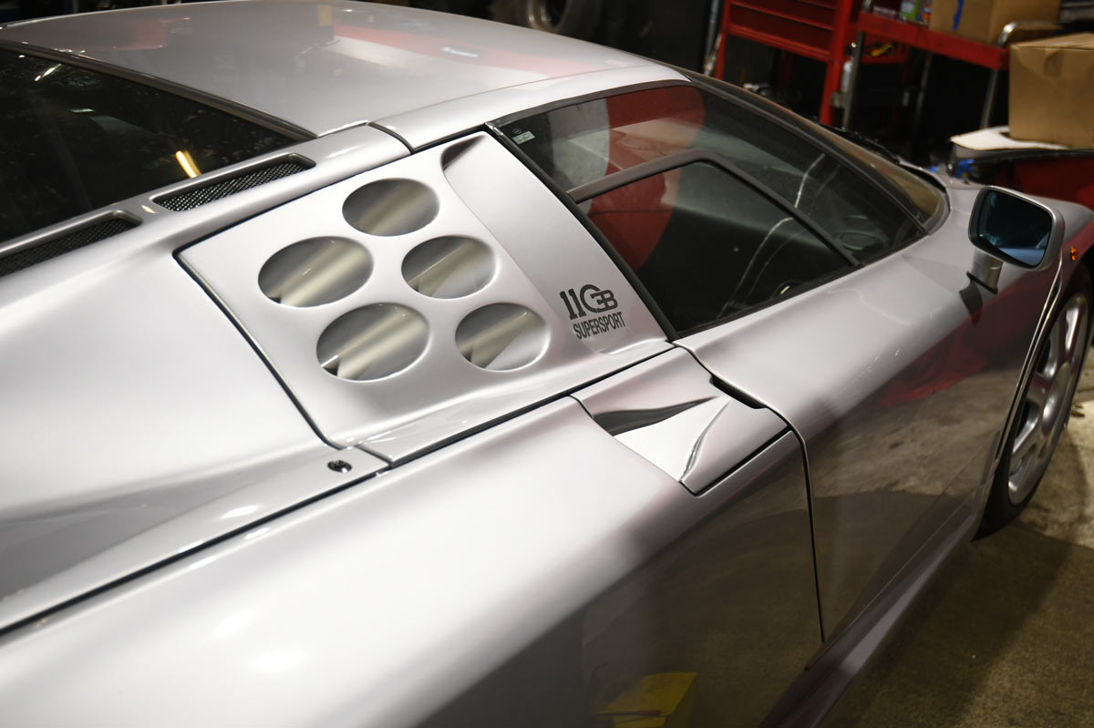 Bugatti EB110 SuperSport 110 SS side badge and six-hole engine intake vent in Reseda workshop